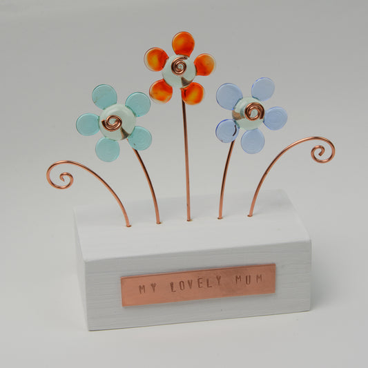 Painted wooden block with three glass flowers in different colours and copper plague reading my lovely mum