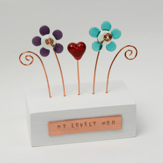 Wooden block with two glass flowers and a heart with copper plaque reading my lovely mum