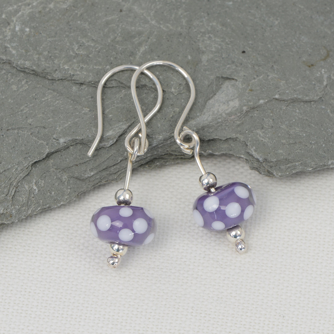 Encased purple with white spots glass bead earrings